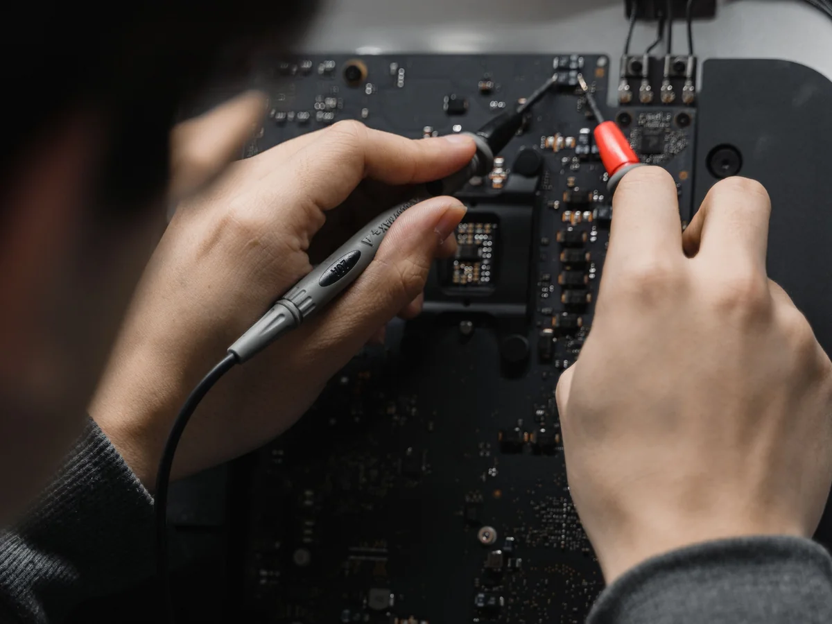 Technician testing a motherboard during chip level repair