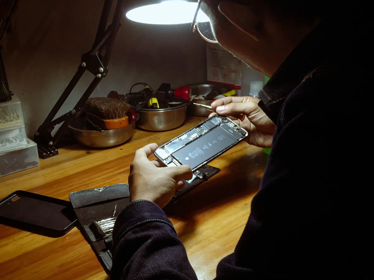 Technician working on an opened smartphone for OnePlus repair